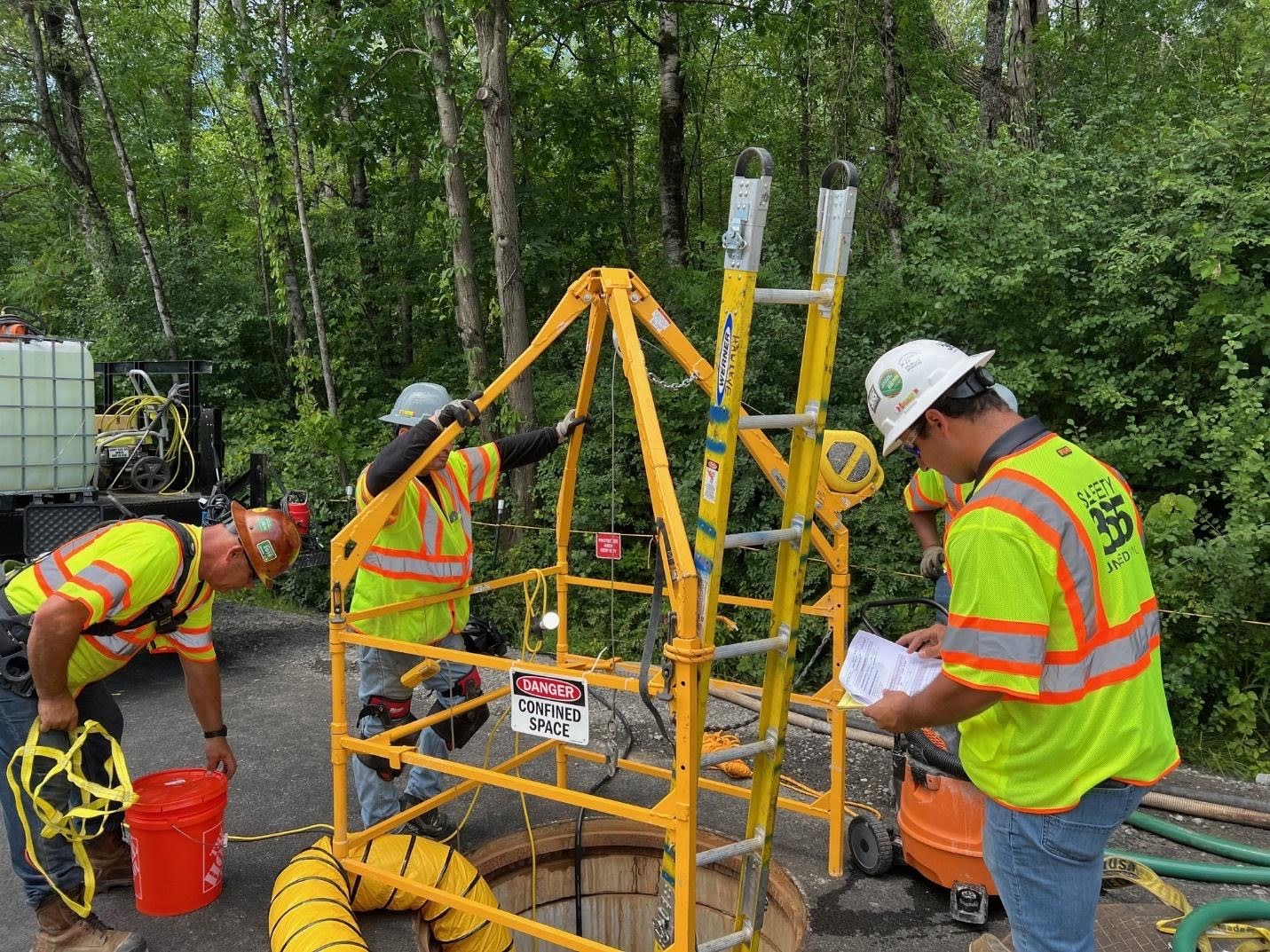 United Civil safety-trained crew rigging equipment on an outdoor utility construction project
