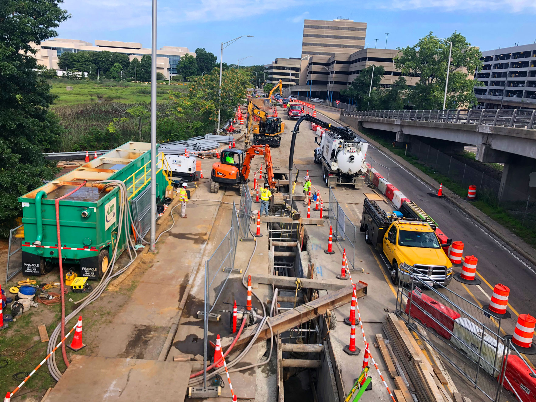 United Civil crew safely operating heavy equipment during underground utility excavation in a live urban work zone